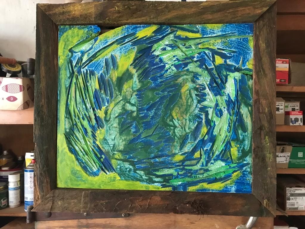 Ein grün-blaues Gemälde in einem Holzrahmen.