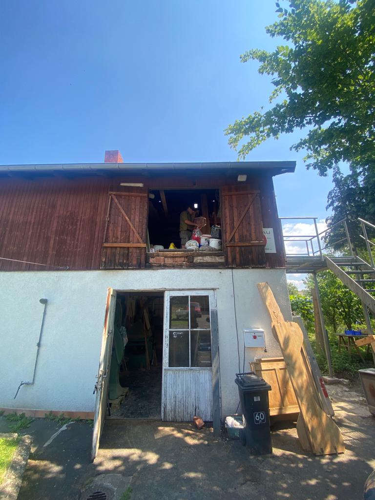 Ein Holzgebäude mit einer Holztür und einer Leiter.