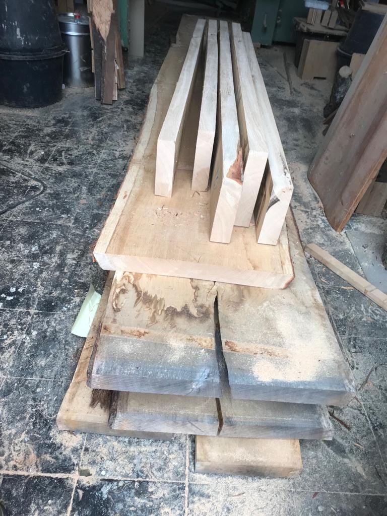 Ein Stück Holz liegt auf einem Tisch in einer Werkstatt.